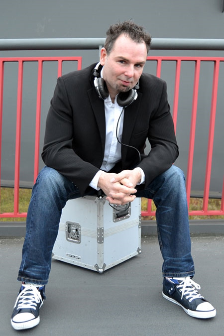 DJ Frank Morris sitzt auf einer Plattenkiste